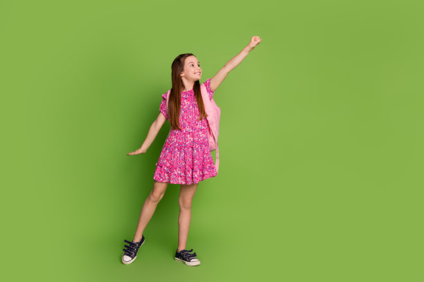 可爱的女学生的全尺寸照片背包空空间穿粉红色的裙子孤立的绿色背景图片下载