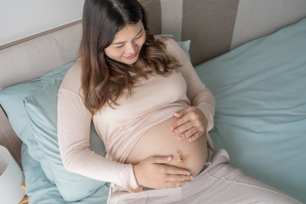 怀孕的亚洲妇女双手放在肚子上抚摸她的孩子，关心她的健康美丽快乐怀孕womanÂ温柔的心情怀孕照片图片下载