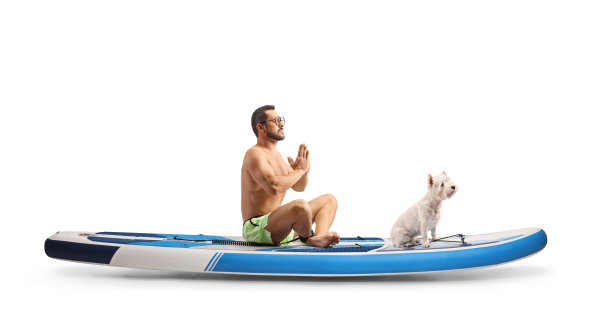 一名男子与一只狗在SUP板上练习冥想的全长侧面照片图片下载