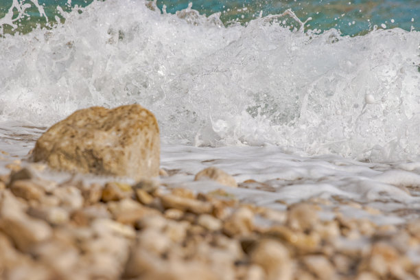 强大的海浪冲击着岩石海滩。海浪拍打着多石的海岸，形成了水花。风景优美的海景。名片、横幅、旅游目录照片。副本的空间。有选择性的重点。图片下载