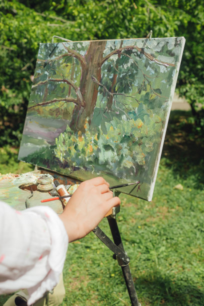 近距离的妇女的手与画笔和油漆附近的画布练习曲。正念，艺术疗法，创意概念。在大自然中进行空气绘画的过程。一系列的照片展示了一幅画的一步一步的创作图片下载