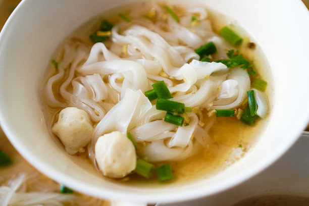 泰国清迈一家街头小吃店，餐桌上的蒸面汤和猪肉球的特写照片。图片下载