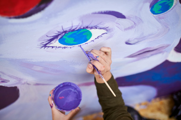 女画家用画笔在帆布上作画，准备参加户外街头展览图片下载