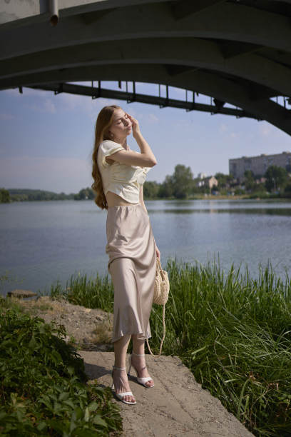 一个漂亮的十几岁的女孩，穿着丝绸裙和老式金钱风格的紧身胸衣。桥下时尚摄影。图片下载