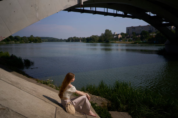 一个漂亮的十几岁的女孩，穿着丝绸裙和老式金钱风格的紧身胸衣。桥下时尚摄影。图片下载