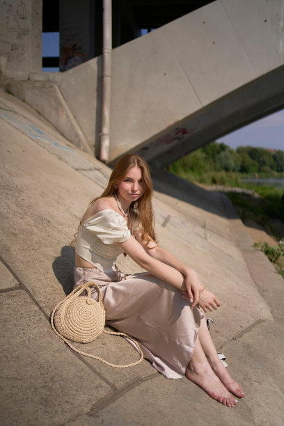 一个漂亮的十几岁的女孩，穿着丝绸裙和老式金钱风格的紧身胸衣。桥下时尚摄影。图片下载