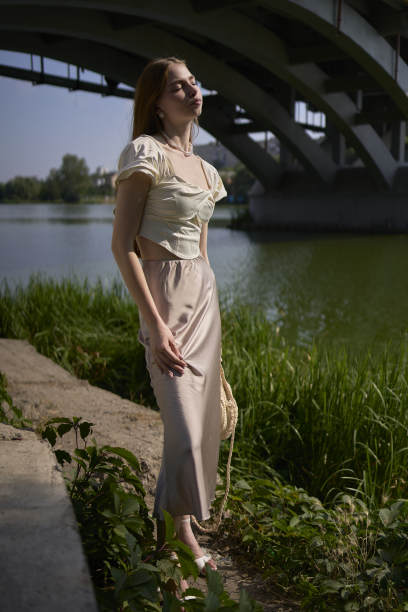 一个漂亮的十几岁的女孩，穿着丝绸裙和老式金钱风格的紧身胸衣。桥下时尚摄影。图片下载