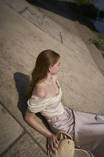 一个漂亮的十几岁的女孩，穿着丝绸裙和老式金钱风格的紧身胸衣。桥下时尚摄影。图片下载