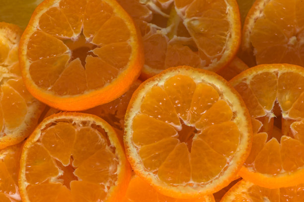新鲜多汁的橘子片或以叶子为背景的橘子图片下载