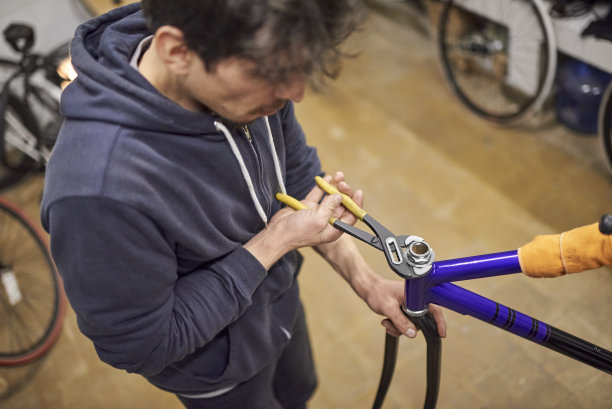 拉丁文修理工在维修期间在他的自行车店里组装自行车图片下载