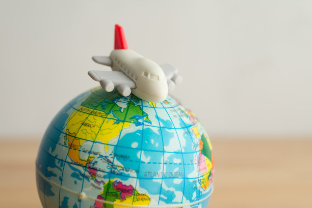 可爱的飞机玩具在世界地球仪与白墙背景复制空间。图片下载