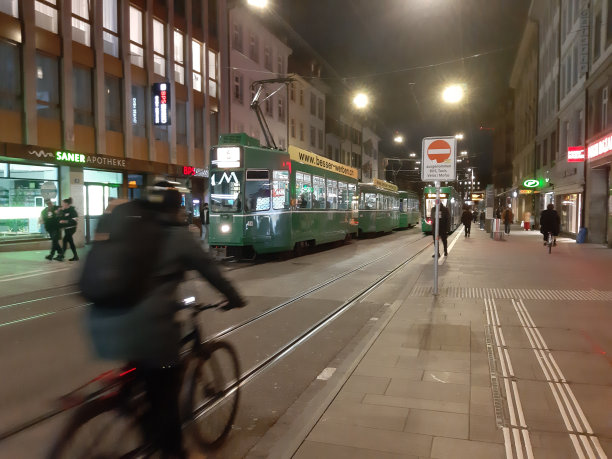 巴塞尔城市公共交通有轨电车站，人们骑自行车，夜晚图片下载