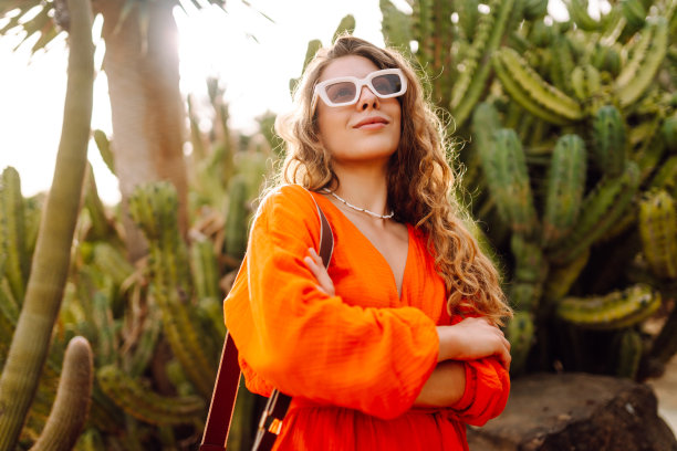时尚时尚的女游客在仙人掌前摆姿势。图片下载