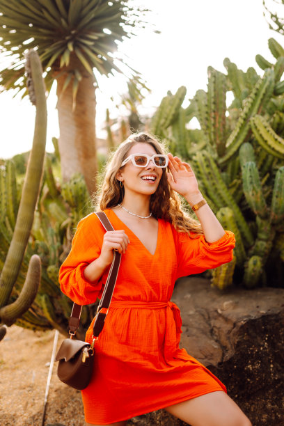 时尚时尚的女游客在仙人掌前摆姿势。图片下载
