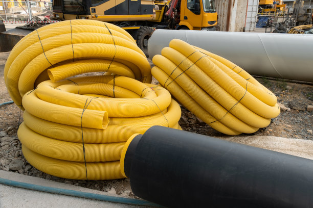 带肋软管或管。PVC卷工业波纹柔性管的地面敷设。电缆施工现场用红色绝缘图片下载