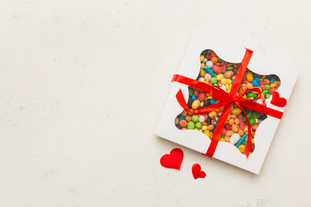 情人节作文:甜甜的糖果，带蝴蝶结和红心毡礼盒，照片模板，背景。带复制空间的俯视图图片下载