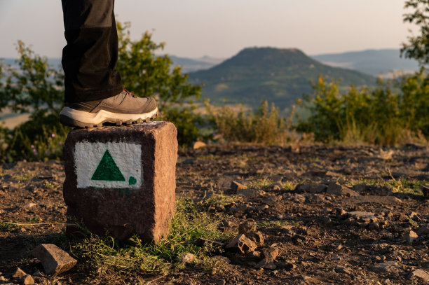 日出时，一位徒步旅行的妇女站在山顶的特写照片图片下载