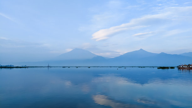 群山倒映在拉瓦坪湖上，以美丽的蓝天为背景图片下载
