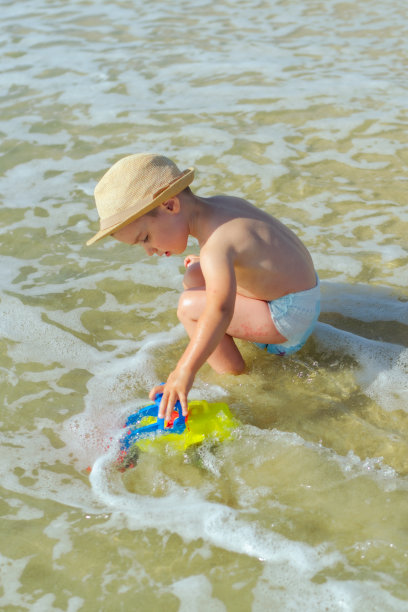 男孩在沙滩上玩耍的照片图片下载