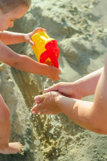 可爱的蹒跚学步的小男孩玩水的股票照片图片下载