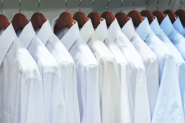 男士衬衫悬挂的特写照片。衣服挂在架子上。衣架与衬衫。男士职业装图片下载