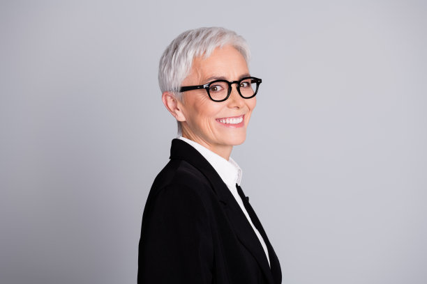 照片漂亮的资深女性专业企业家简介牙齿微笑穿着正装眼镜孤立在灰色背景图片下载