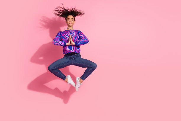 全身照片光泽迷人的女士穿着紫色运动衫跳高享受瑜伽空空间孤立的粉红色背景图片下载