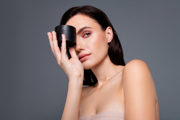 照片的黑发女子隐藏眼睛脸与奶油罐孤立的灰色背景图片下载