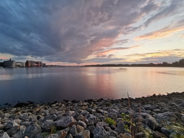 在一个美丽的夏夜，石头落在水面上，雨云笼罩罗斯托克图片下载