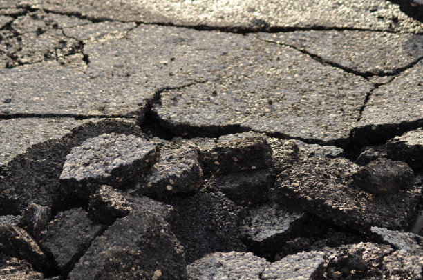 沥青路面桩。柏油受损的危险路段。污水系统修复或事故的概念。沥青开裂，干燥期图片下载