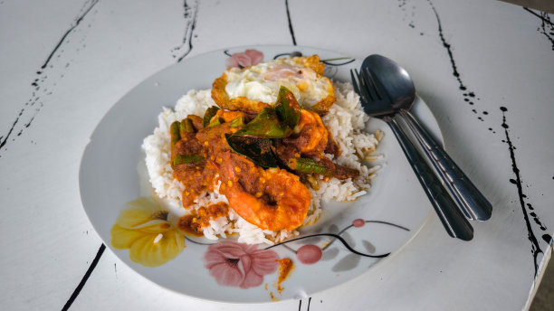 用白盘子盛上咖喱酱炒虾和米饭，上面放上煎蛋。图片下载