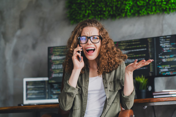 可爱自信成功女性的照片系统管理员编码员工作现代工作站在室内说话喊电话图片下载