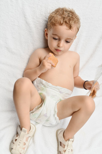 幼儿在躺椅上晒日光浴和吃饼干的高角度照片图片下载