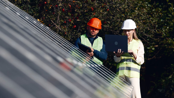 女性生态工程师使用项目文件和文件，收集有关太阳能电池板的有效信息。光伏太阳能农场。绿色能源。环境。绿色能源的概念图片下载