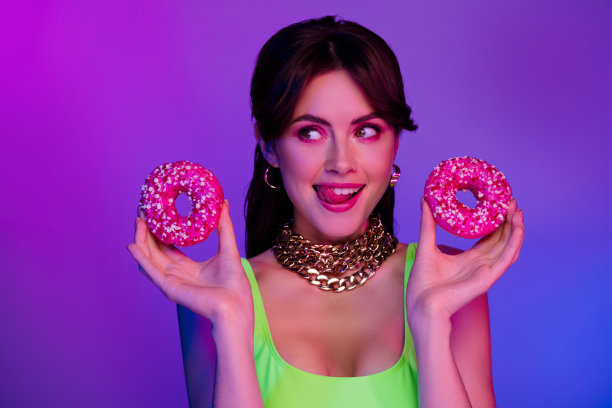 照片的女孩穿背心拿饼干舔嘴唇享受风味隔离紫外线的颜色背景图片下载