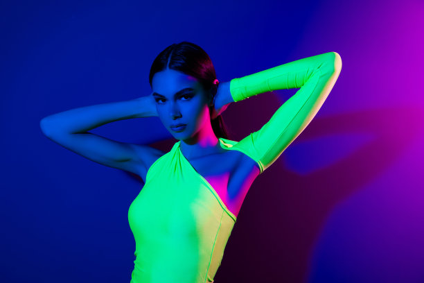 照片可爱的热辣花式模特女孩的手臂触摸头空空间孤立的紫色霓虹背景图片下载