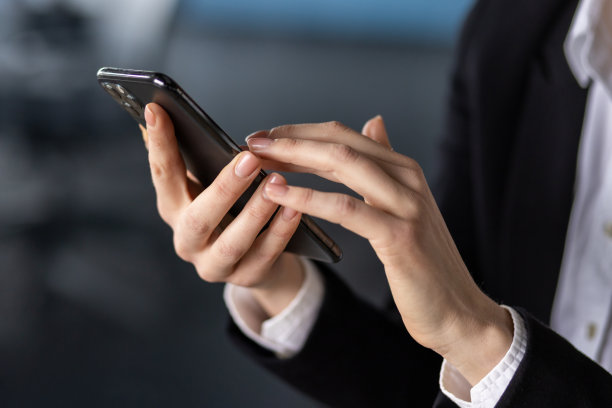 在办公环境中使用智能手机的手特写图片下载