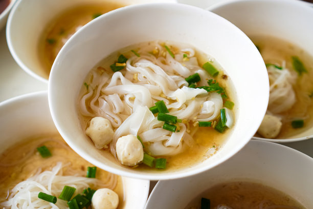 泰国清迈一家街头小吃店，餐桌上的蒸面汤和猪肉球的特写照片。图片下载