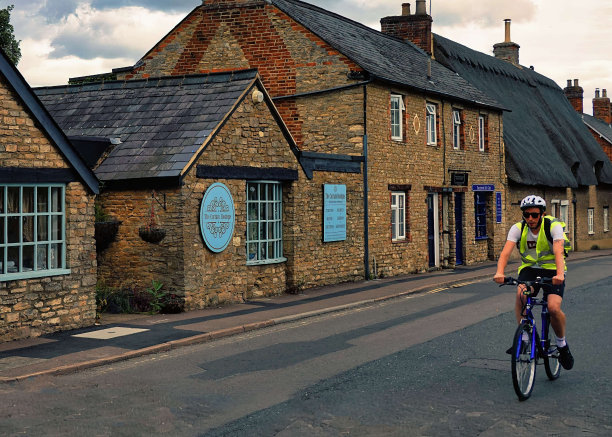 骑自行车的人穿过英国贝德福德郡的村庄图片下载