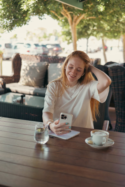咖啡厅里拿着智能手机的女人图片下载