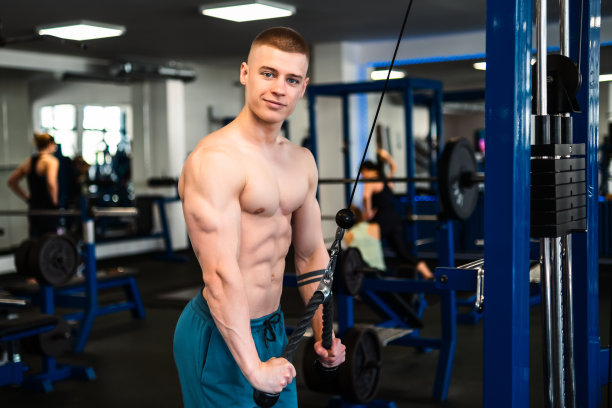 男子在健身房用拉线机训练三头肌的照片图片下载