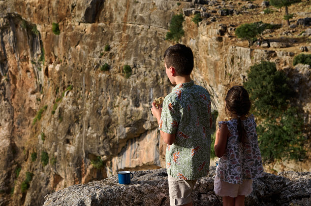 孩子们探索自然，在岩石峭壁上享用零食图片下载