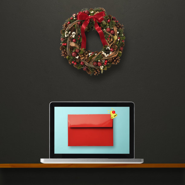 墙上挂着圣诞花环的笔记本电脑，显示着电子邮件图片下载