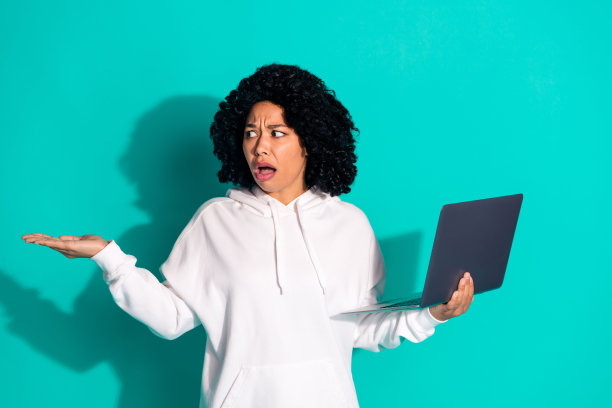 年轻有趣的雪佛兰发型女士的照片，穿着白色卫衣，使用笔记本电脑，留下深刻的印象，示范交易孤立的海蓝宝石色背景图片下载