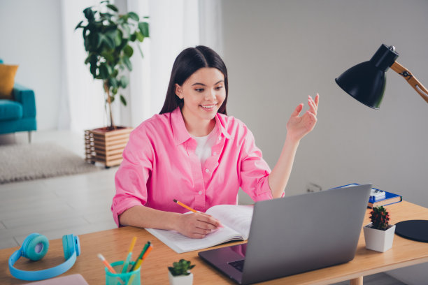 照片积极的好心情的女人穿着粉红色的衬衫远程教育现代化设备室内房子公寓房间图片下载