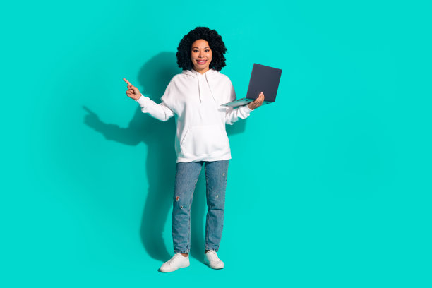 年轻卷发女孩的照片穿着白色卫衣在线演示孤立的海蓝宝石色背景图片下载