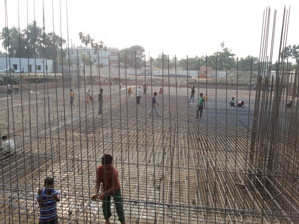 2024年7月25日，孟加拉国达卡。这张照片拍摄了一群人在一个大型露天建筑工地从事各种活动。图片下载