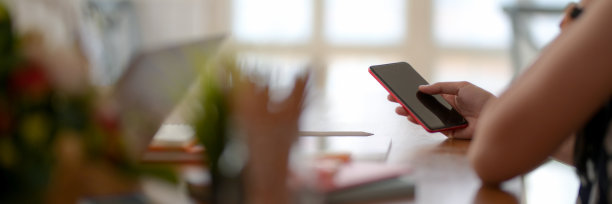 裁剪后的女性在办公室使用手机的图片图片下载