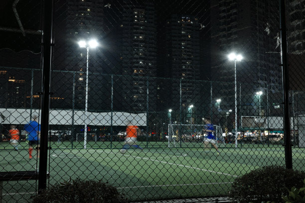 人们晚上在室外足球场踢足球图片下载