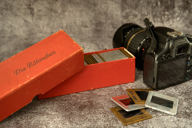 幻灯片放在储物盒里，旁边放着数码相机图片下载